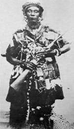 Photographie en noir et blanc de Yaa Asantewaa portant une arme
